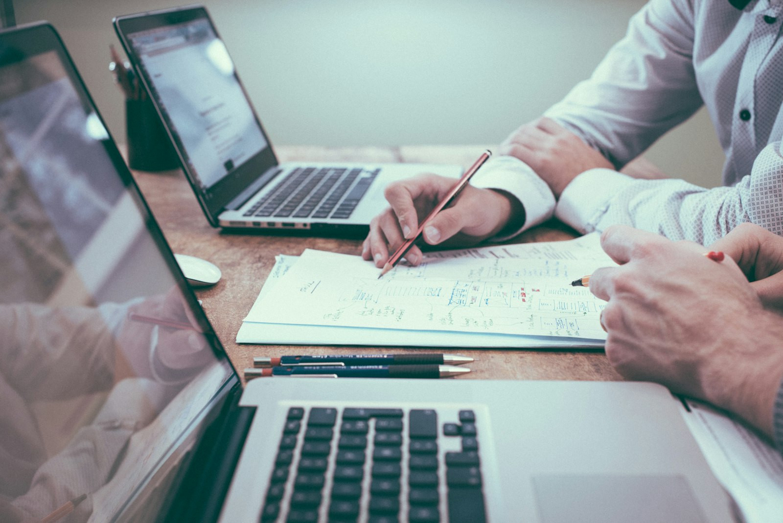 Business documents, charts, and a laptop on a desk during a deal review, illustrating an FBA business sale